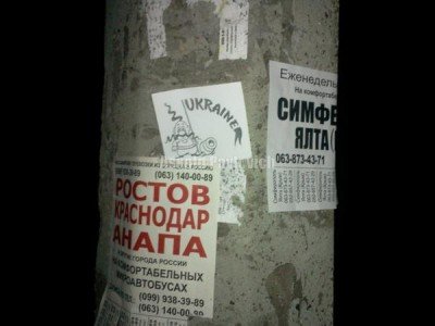 На столбе наклейка с казачком и пушкой